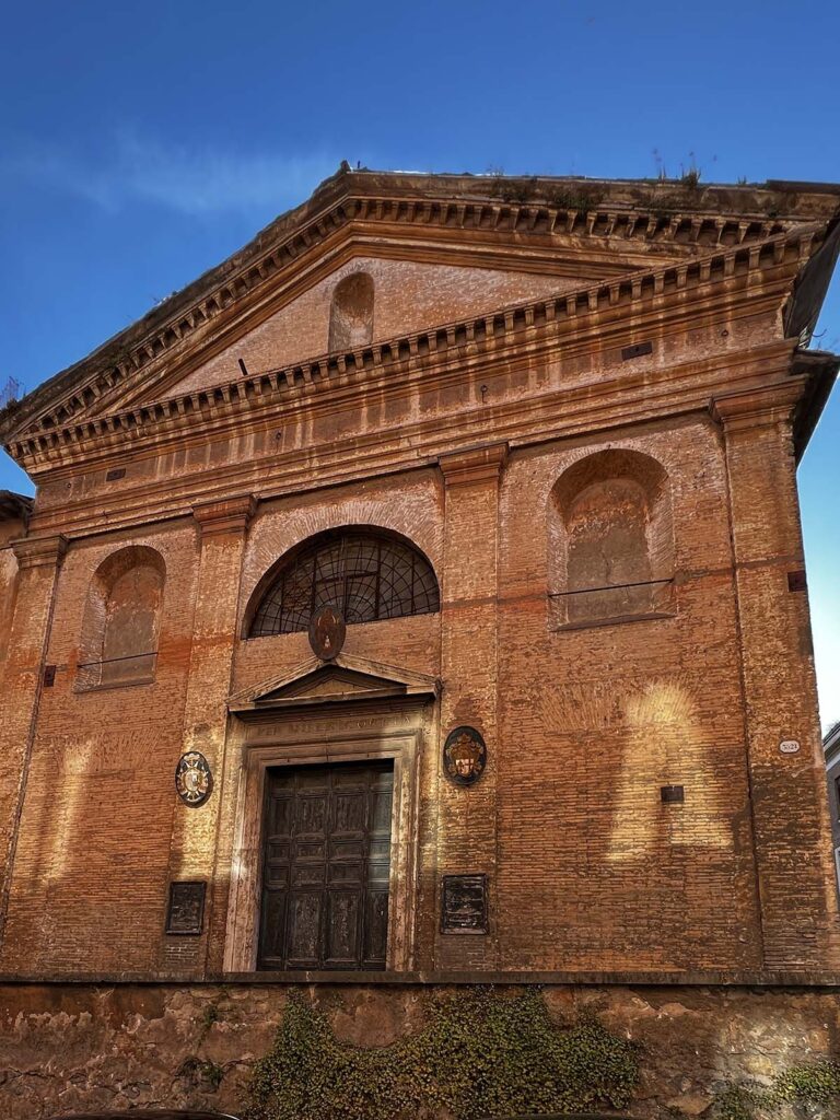 Facciata della chiesa di San Giovanni Decollato a Roma illuminata dalla luce del tramonto.