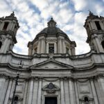 Facciata barocca della chiesa di Sant’Agnese in Agone a Roma vista dal basso con cielo nuvoloso.