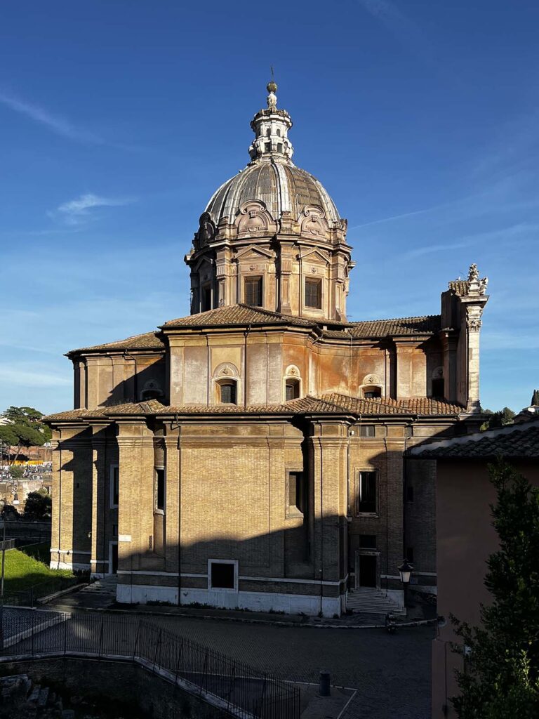 Facciata laterale della chiesa dei Santi Luca e Martina al Foro Romano illuminata dalla luce del tramonto.