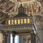 Interno dell’abside della basilica di San Pietro in Vincoli a Roma, con il ciborio decorato e gli affreschi rinascimentali sullo sfondo.