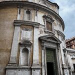Facciata della chiesa di San Bernardo alle Terme a Roma, con portale aperto e cielo nuvoloso.