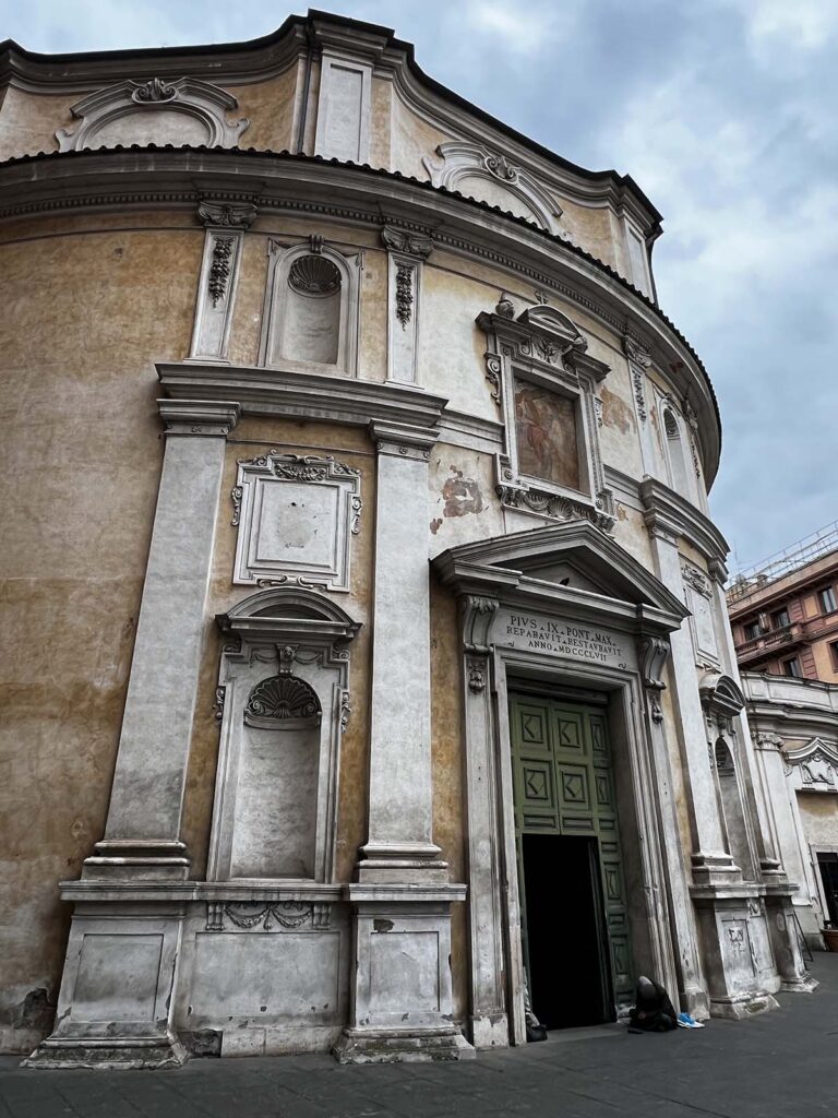 Facciata della chiesa di San Bernardo alle Terme a Roma, con portale aperto e cielo nuvoloso.