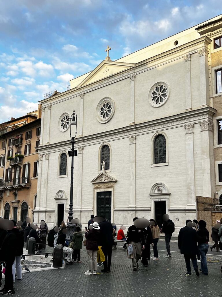 Facciata del Santuario di Nostra Signora del Sacro Cuore a Piazza Navona con persone radunate nella piazza.
