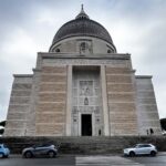 Facciata della Basilica dei Santi Pietro e Paolo all’Eur vista frontalmente in una giornata nuvolosa.