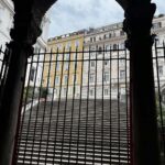 Esterno della chiesa di San Vitale al Quirinale visto dall’interno, con la scalinata che sale verso Via Nazionale e palazzi storici sullo sfondo.